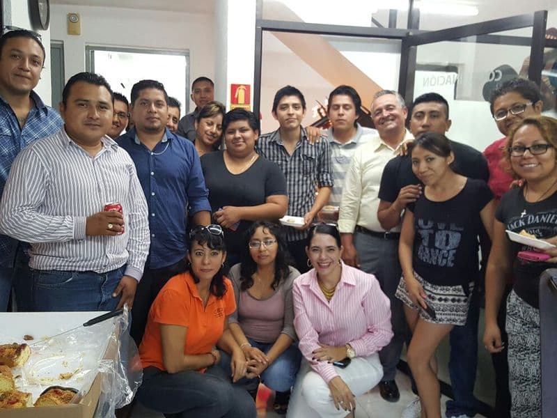 Grupo de egresados de Cyade Cancún celebrando con su profesora